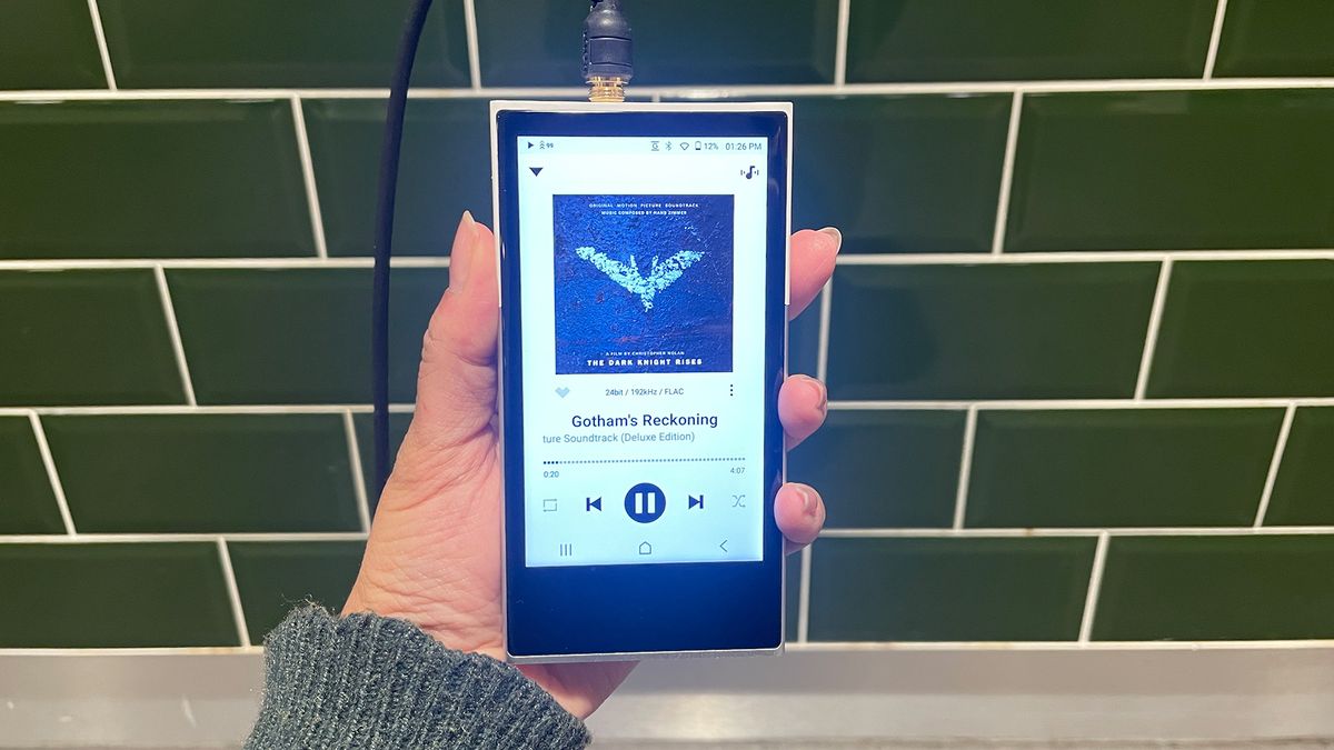 Activo P1 hi-res music player held in hand against green bathroom tiles