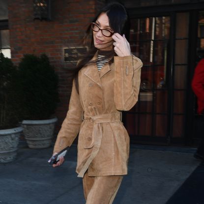 Bella Hadid leaves the Bowery Hotel in New York City wearing a rich suede suit with a striped t shirt underneath