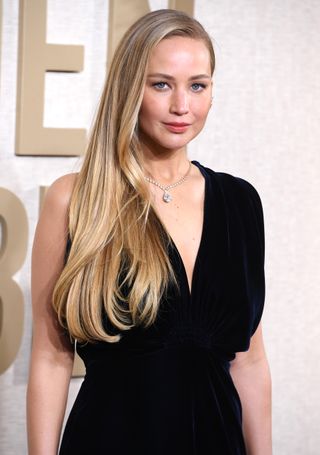 Jennifer Lawrence with her hair long layered blonde hair parted to the side.