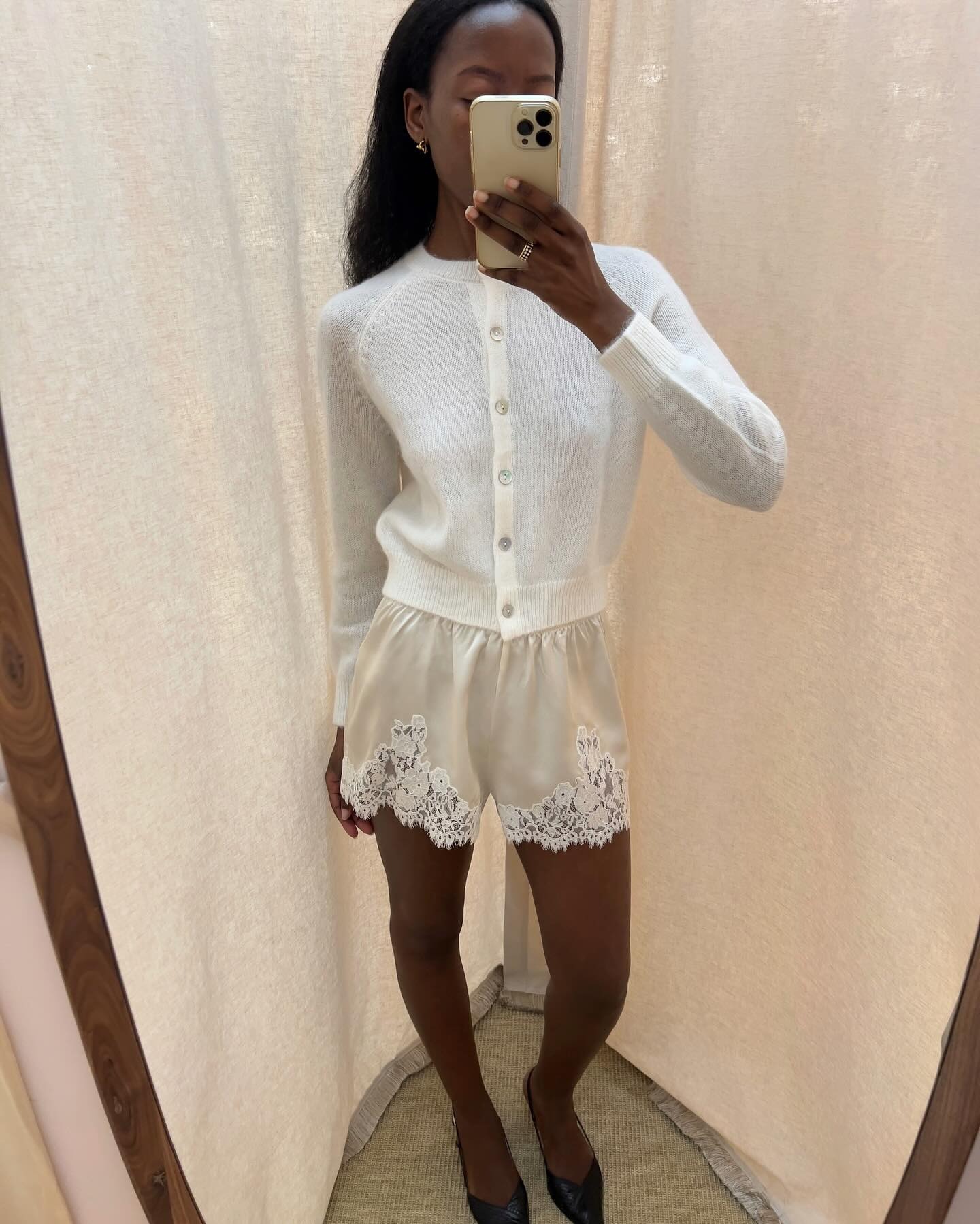 @sylviemus_ wearing Doen lace-trim shorts and a white cardigan