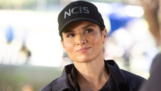 Jessica Knight smiling while wearing an NCIS hat. 