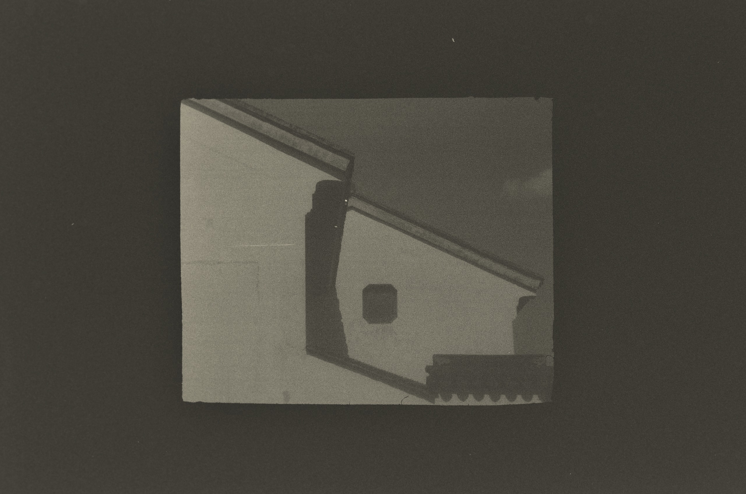 A black-and-white print by Jing Huang of a whitewashed Suzhou gable wall with a sloping dark roof ridge, a small square window and a row of scalloped roof tiles.