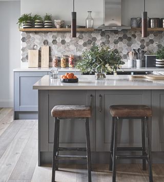 Blue kitchen island with cabinets and leather stools