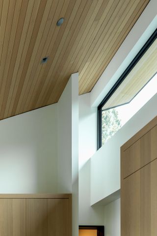 Maple Place house's ceiling structure, showing clean geometries and clerestory window looking out towards the trees