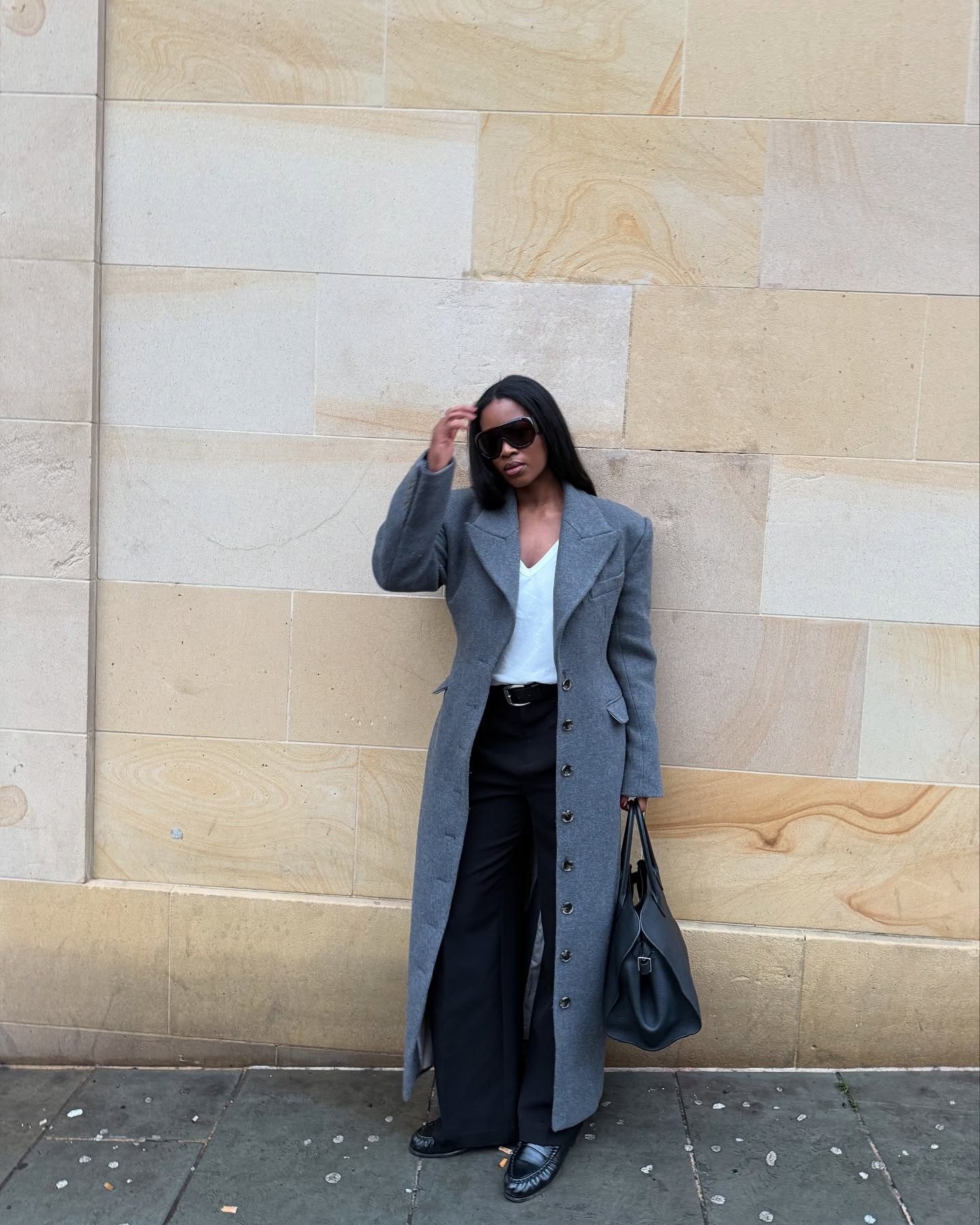 An influencer wearing a black trousers outfit.