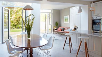 Open plan living space with dining table next to a kitchen and seating area to show how to declutter your home for a tidy environment
