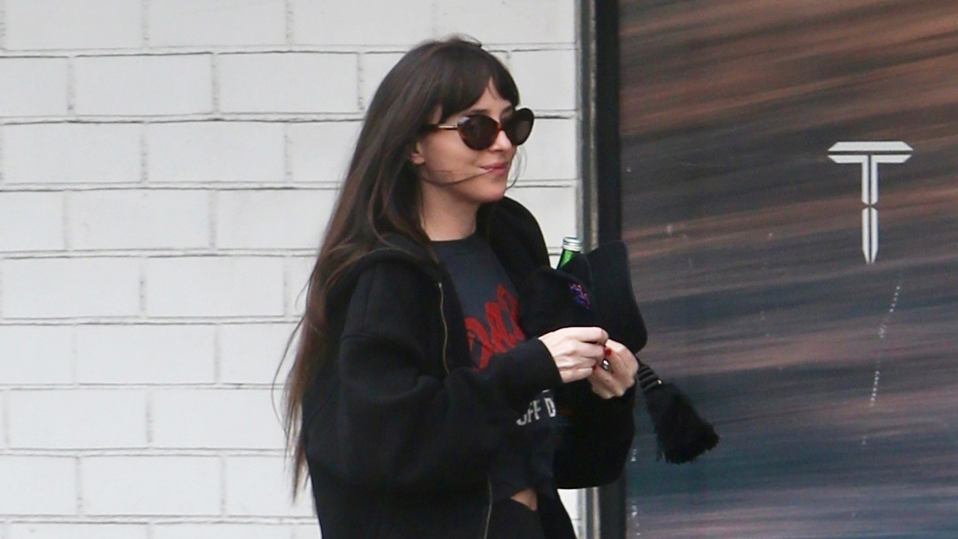 Dakota Johnson wearing sweatpants over leggings