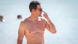 Mark Wahlberg walking on beach with sunglasses 