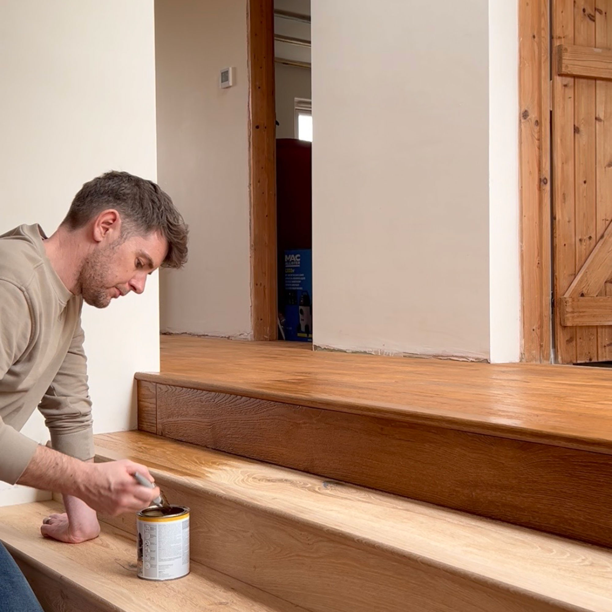 Man staining wooden stairs
