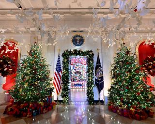 The Seal of the President of the United States sits high above Christmas decorations in the Cross Hall during the 2024 White House Holiday media preview in Washington, DC