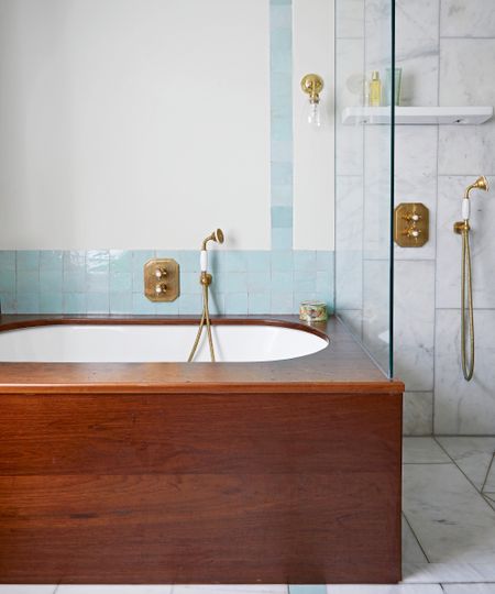 neutral bathroom with bath with wooden surround, shower cubicle and pale blue zelige tile backsplash