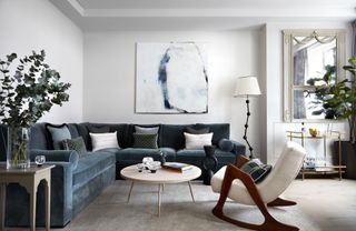 A living room with grey walls and a blue sofa