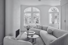 an off white living room in a minimalist style with white walls and a warm white sofa