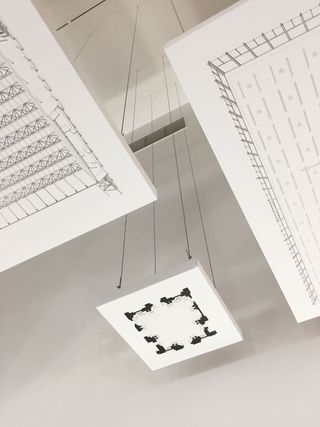 Hanging architectural plans at ’The Economy of Means’ exhibition