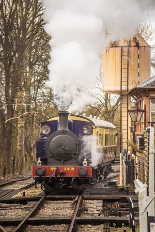 This stretch of track at the Didcot Railway Centre was straight, but a slight curve by the water tower meant the carriages were in sight. A fast shutter speed froze the moving train