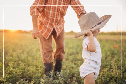 child and adult stood in a field with a cowboy hat on