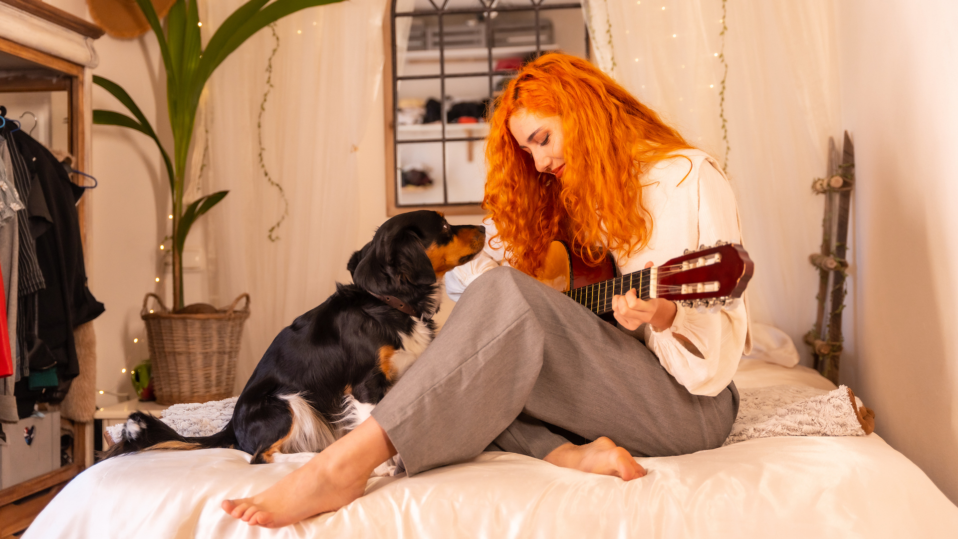 Girl singing and playing guitar with dog