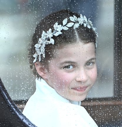 Princess Charlotte wearing a diamond leaf crown riding in a carriage at King Charles's coronation