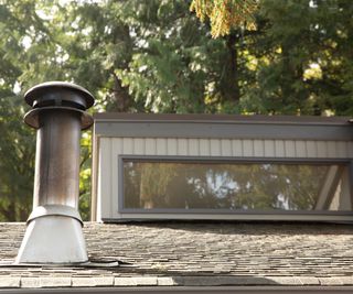 A chimney poking out of a tiled roof