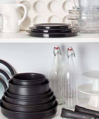 A set of stackable pans in a cupboard