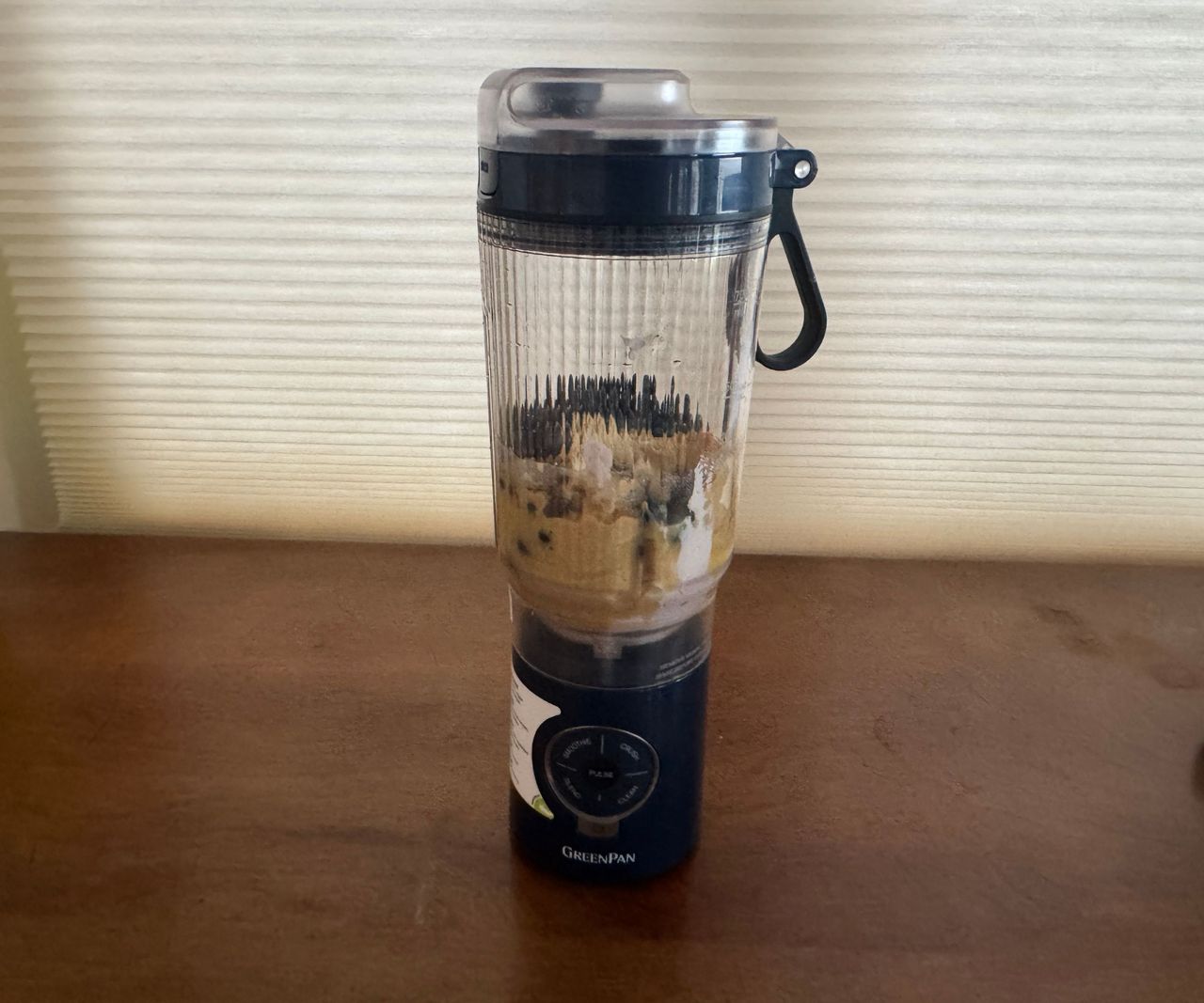 A smoothie mix inside a small black portable blender.