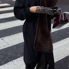 @hannahlewisstylist closeup shot of zebra print gloves, fur scarf, and burgundy bag