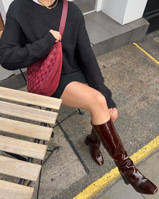 Stiefel-Trends im Herbst 2024: Influencer tragen burgunderfarbene Lackstiefel mit schwarzen Miniröcken