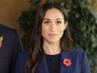 Meghan Markle wearing a blue blazer and red poppy pin