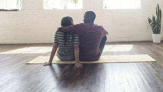 Young couple sitting on carpet in a loft