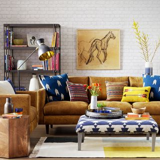 living area with white wall and art work and brown sofa