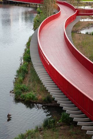 Asif Khan boardwalk at Canada Water bright red bridge across water and natural water wildlife habitat