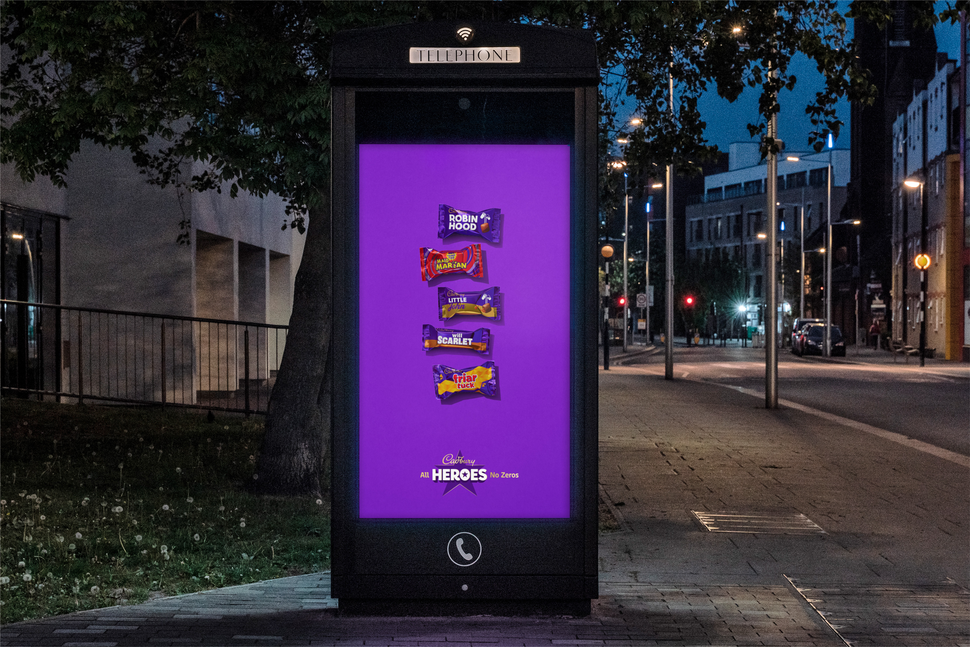 An outdoor digital advertisement on a telephone box at night featuring five miniature Cadbury&#039;s chocolate bars named after characters from the Robin Hood legend (Robin Hood, Marian, Little John, Maid Scarlet, Friar Tuck) over a purple background with the slogan &amp;quot;Cadbury All HEROES No Zeros.&amp;quot;