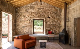 The living area with an exposed chestnut ceiling and stone walls