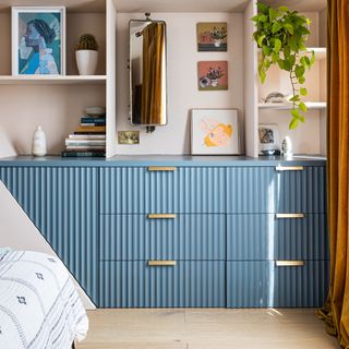 Bedroom with blue ribbed drawers and open shelving