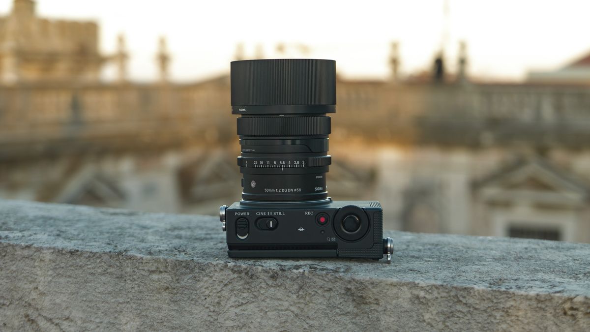 Sigma FP2 mirrorless camera with the 50mm f/2 contemporary lens attached, placed on a marble wall, at golden hour