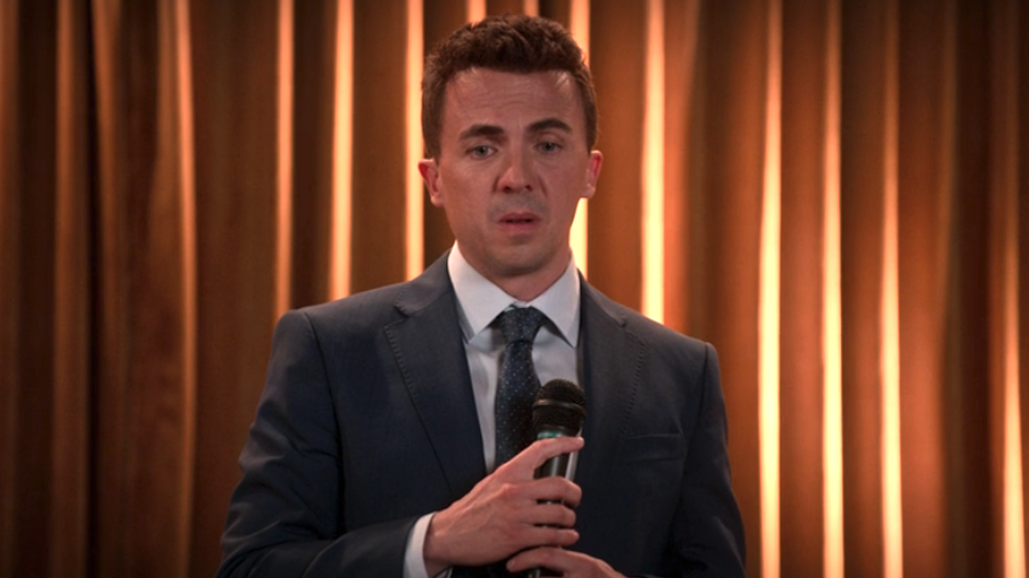 Frankie Muniz on a stage with a mic in Malcolm in the Middle: Life's Still Unfair