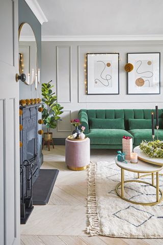 elegant living room with a green velvet sofa, nest of tables and `Christmas decorations
