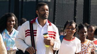 Will Smith in King Richard, alongside a crowd of people including his in-movie daughters