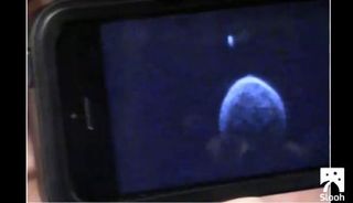An image of asteroid 2004 BL86 taken the morning of Jan. 26, the day of its closest approach to Earth, shows a moon orbiting just above the asteroid, and indications of surface features like boulders. This photo was shown by NASA's Lance Benner during a webcast aired by the Slooh Community Observatory.