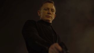 Daniel Craig grimly aims his gun at a target off camera in Spectre.