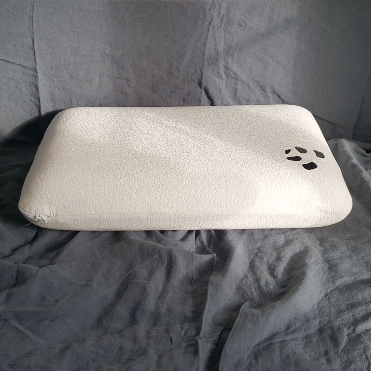 The Panda Memory Foam pillow laid flat to show the depth on grey bed linen