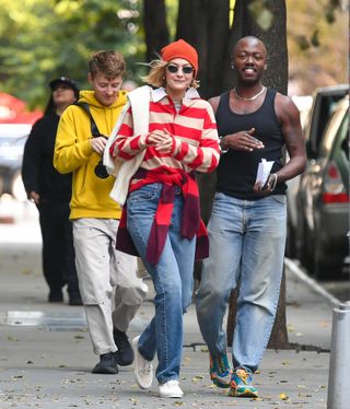 A photo of Gigi Hadid in an orange beanie and jeans