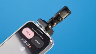 the shure mv88 usb-c microphone photographed against a blue tom's guide background and shown connected to a google pixel 10 pro