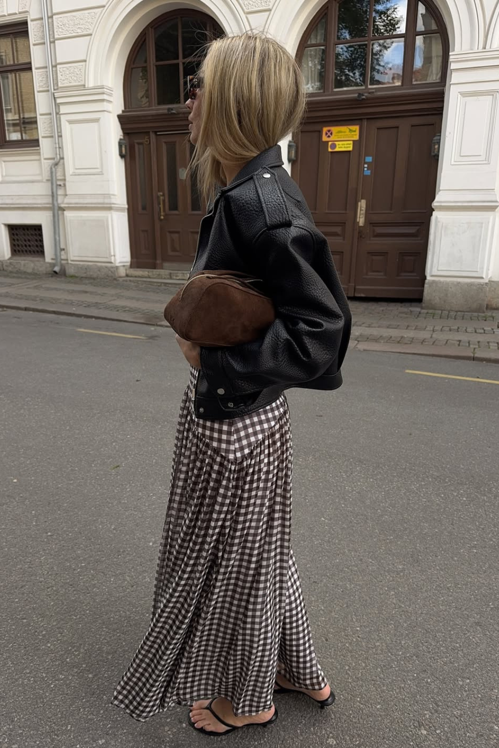 @emelieolson wears gingham skirt, leather jacket, suede bag