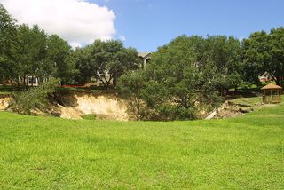 A sinkhole opened up near the Woodhill Apartments in Orlando, Florida, on June 11, 2002. Shown here on June 12, the sinkhole measured 150 feet wide and 60 feet deep (45 by 18 meters).