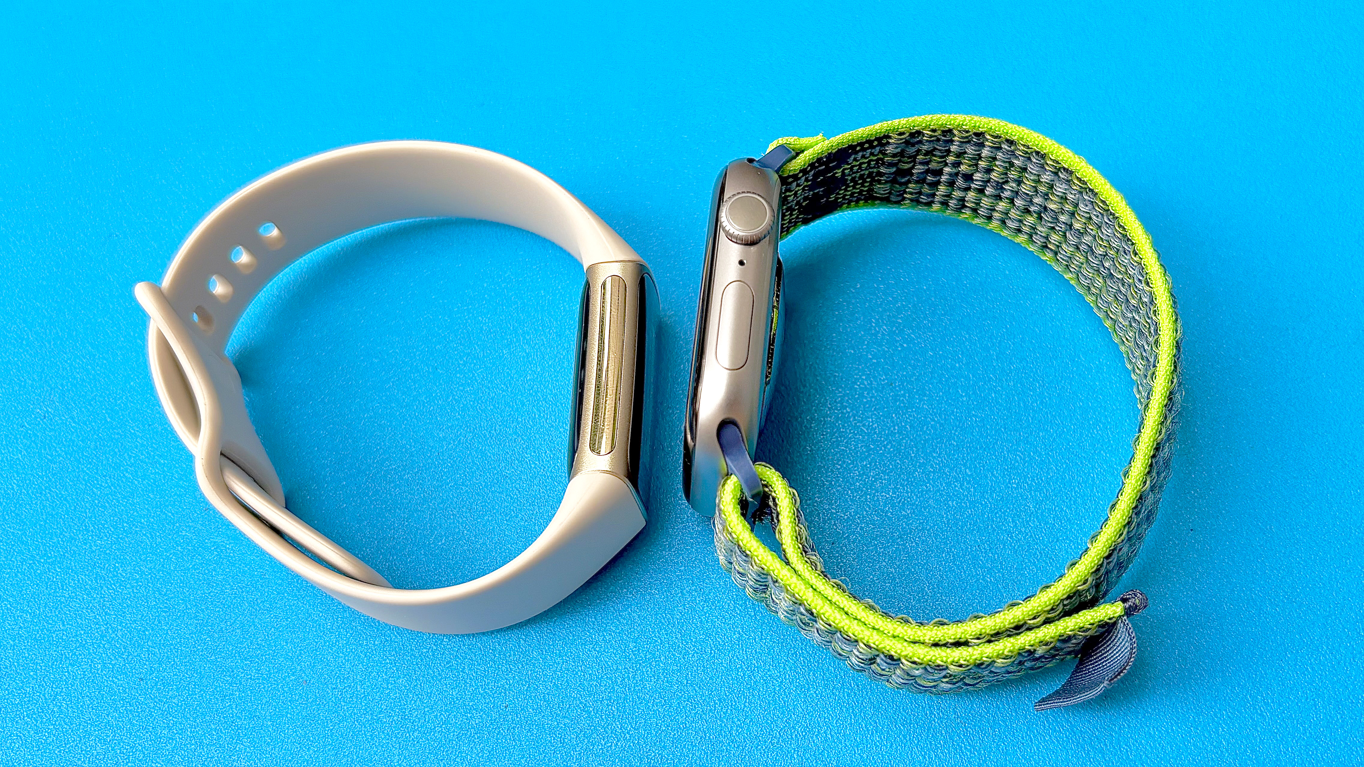 Close-up of the Fitbit Charge 5 next to the Apple Watch Series 11