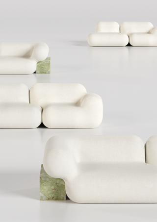 White, curved sofas and green stone side tables