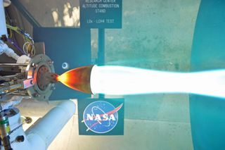 A rocket engine fueled by liquid methane and liquid oxygen fires in a test at Glenn Research Center's Altitude Combustion Stand.