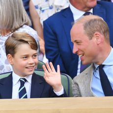 Prince George wears a blue suit and waves at the crowd as his dad Prince William laughs