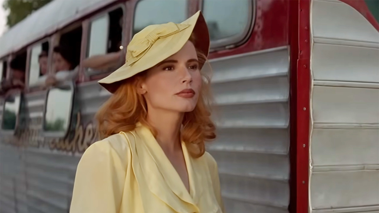 Shot of Dottie Hinson standing outside of the baseball bus after losing the final game of the season. She is wearing a yellow dress an hat.
